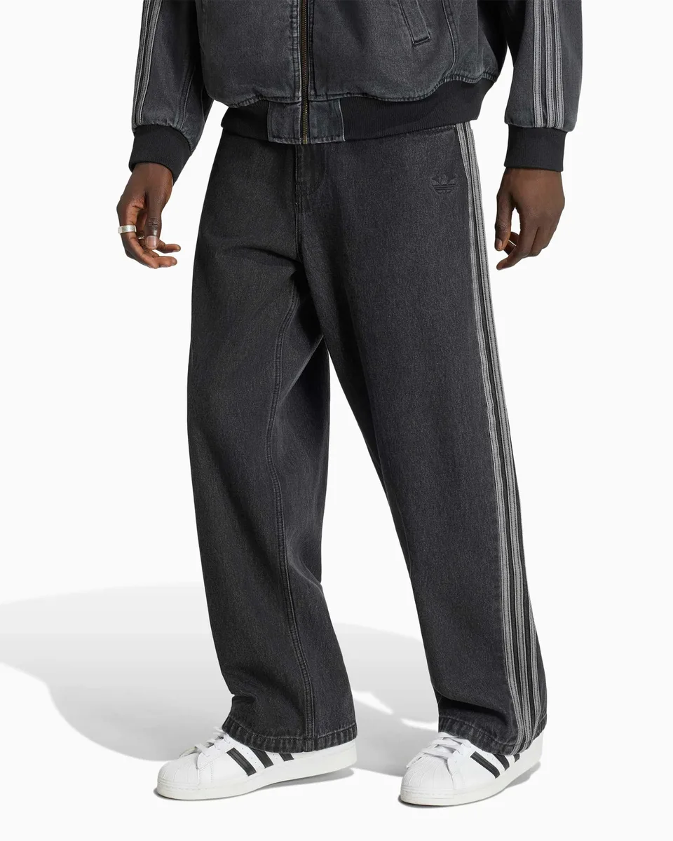 Sneakers Adidas bianche indossate con pantaloni neri